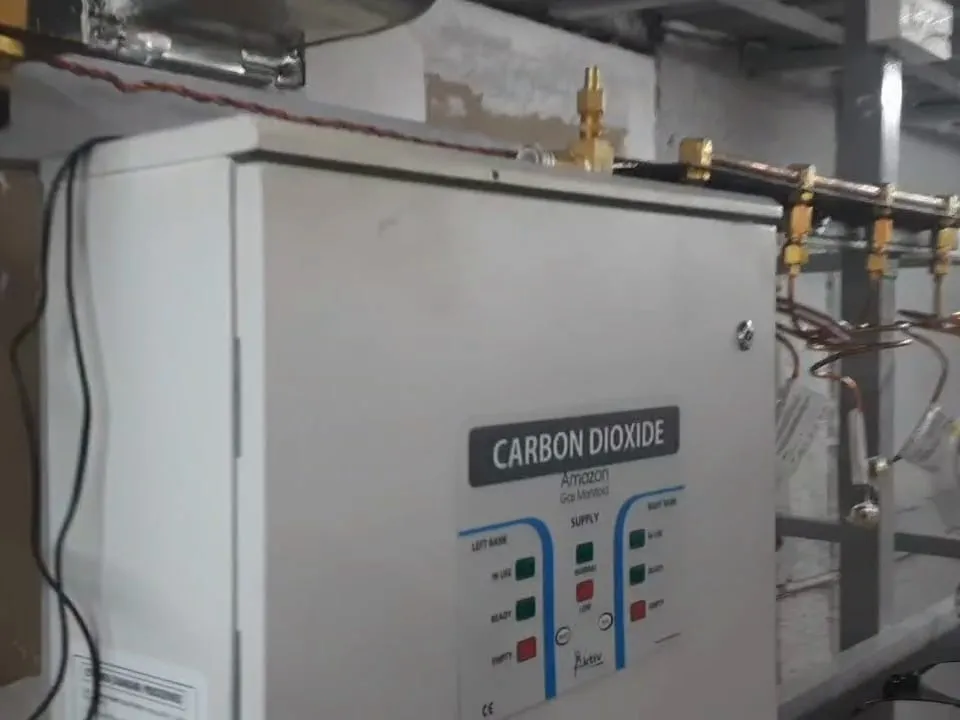 A wall-mounted carbon dioxide manifold control panel next to its copper tails.